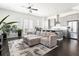 Bright open-concept living room with hardwood floors, modern sofa, and stainless steel appliances at 3905 Danube Ln # 215, Atlanta, GA 30339
