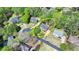 An aerial view showcases a beautiful brick home nestled among lush, mature trees at 865 Mount Katahdin Trl, Johns Creek, GA 30022