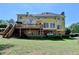 Two-story yellow house with a large deck and walkout basement on a large grassy lot at 865 Mount Katahdin Trl, Johns Creek, GA 30022