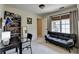 Spare room with a gray futon sofa and desk next to a window with neutral wall paint at 865 Mount Katahdin Trl, Johns Creek, GA 30022