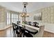 Formal dining room with hardwood floors, patterned wallpaper, wainscoting, a chandelier, and large windows at 865 Mount Katahdin Trl, Johns Creek, GA 30022