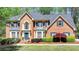 Charming two-story brick home with manicured landscaping and a welcoming front entrance, exuding curb appeal at 865 Mount Katahdin Trl, Johns Creek, GA 30022