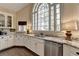 Kitchen with white cabinets, granite countertops, stainless steel appliances, and a large arched window at 865 Mount Katahdin Trl, Johns Creek, GA 30022