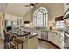Kitchen with white cabinets, granite countertops, stainless steel appliances, and a large arched window at 865 Mount Katahdin Trl, Johns Creek, GA 30022