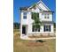Newly built two-story home with white siding, black shutters, and a newly planted tree at 354 Friendship Oak Way, Hampton, GA 30228