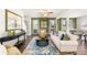 Open-concept living room with hardwood floors, a plush sofa, and natural light streaming through the windows at 354 Friendship Oak Way, Hampton, GA 30228