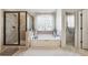 This bright bathroom offers a large soaking tub, glass enclosed shower, and stylish tile, promoting relaxation at 3613 Lake Estates Way, Atlanta, GA 30349