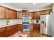 Kitchen featuring stainless steel appliances, wood cabinets, granite countertops, and hardwood floors at 3613 Lake Estates Way, Atlanta, GA 30349