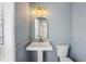 Charming bathroom features pedestal sink, designer lighting and neutral paint at 6244 Marbut Farms Trl, Lithonia, GA 30058