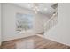 Bright entryway with hardwood floors, large window, modern lighting fixture, and white staircase at 6244 Marbut Farms Trl, Lithonia, GA 30058
