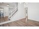 Bright entryway with hardwood floors, white staircase and banister, and modern lighting fixtures at 6244 Marbut Farms Trl, Lithonia, GA 30058