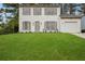 Charming two-story home with a lush green lawn and a quaint, welcoming facade and attached garage at 6244 Marbut Farms Trl, Lithonia, GA 30058