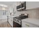 Close up of a modern kitchen with stainless steel appliances, white cabinets, and stylish backsplash at 6244 Marbut Farms Trl, Lithonia, GA 30058