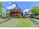 Back exterior view of a home featuring a deck, patio, and manicured lawn at 955 Bishopswood Pl, Johns Creek, GA 30022