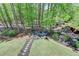 Backyard firepit area surrounded by mature trees, creating a serene outdoor space at 955 Bishopswood Pl, Johns Creek, GA 30022