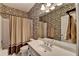 Charming bathroom with floral wallpaper, vanity with a white countertop, and classic fixtures at 955 Bishopswood Pl, Johns Creek, GA 30022