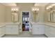 Bright bathroom with double vanity, framed mirrors, and marble countertops leading to an open doorway and bedroom at 955 Bishopswood Pl, Johns Creek, GA 30022