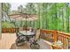 Relaxing outdoor deck area featuring a dining table set and wooded views at 955 Bishopswood Pl, Johns Creek, GA 30022