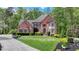 Beautiful two-story brick home with manicured lawn and lush landscaping at 955 Bishopswood Pl, Johns Creek, GA 30022