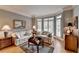 Cozy living room showcasing hardwood floors, neutral paint, and bay windows at 955 Bishopswood Pl, Johns Creek, GA 30022