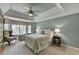 Tranquil main bedroom features a tray ceiling, ceiling fan, and large bay windows at 955 Bishopswood Pl, Johns Creek, GA 30022