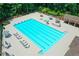 Aerial view of a community pool with lounge chairs and umbrellas, perfect for relaxing and enjoying the summer sun at 955 Bishopswood Pl, Johns Creek, GA 30022