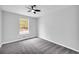 Well-lit bedroom with neutral walls, carpeted flooring, a ceiling fan, and natural light from the window at 175 Montego Cir, Riverdale, GA 30274