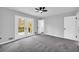 Bright bedroom featuring a ceiling fan, gray walls, gray carpet, and french doors that lead to a deck at 175 Montego Cir, Riverdale, GA 30274