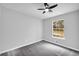 Well-lit bedroom with a ceiling fan, a view from the window, gray walls, and carpeted flooring at 175 Montego Cir, Riverdale, GA 30274