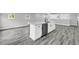 Open-concept kitchen island with stainless steel dishwasher, white cabinets, and quartz countertop, next to gray floor at 175 Montego Cir, Riverdale, GA 30274