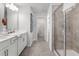 Bathroom featuring double sinks, a framed mirror, and a glass shower at 522 Provence Gate Ln, Lawrenceville, GA 30044