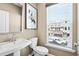Elegant powder room featuring a pedestal sink, toilet, mirror, and a window with neighborhood views at 522 Provence Gate Ln, Lawrenceville, GA 30044