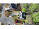 Overhead view of brick house featuring manicured lawn, mature trees, and winding driveway at 5717 Harmony Point Dr, Lilburn, GA 30047