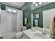 Stylish bathroom with a palm tree theme, white tiles, and a dark green wall at 5717 Harmony Point Dr, Lilburn, GA 30047