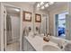 Bright bathroom features a double vanity, framed art, and a shower and tub combo with beige tile at 5717 Harmony Point Dr, Lilburn, GA 30047