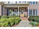 Inviting front porch with decorative plants, outdoor seating and a beautiful wooden front door at 5717 Harmony Point Dr, Lilburn, GA 30047