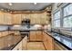 Spacious kitchen with wood cabinets and black countertops plus lots of sunlight at 5717 Harmony Point Dr, Lilburn, GA 30047