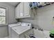 Well-lit laundry room with built-in cabinets, utility sink, washer, and dryer at 5717 Harmony Point Dr, Lilburn, GA 30047