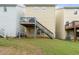 A home's back exterior with a wooden deck, staircase, and a well-maintained lawn, enhancing outdoor living at 6389 Shadow Sq, Lithonia, GA 30058