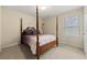 Serene bedroom featuring a four-poster bed, neutral tones, and a bright window at 6389 Shadow Sq, Lithonia, GA 30058