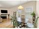 Bright dining area featuring a wooden table set, hardwood floors, and natural light at 6389 Shadow Sq, Lithonia, GA 30058