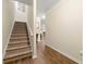 Well-lit staircase with wooden steps and handrail, leading to the upper level of the home at 6389 Shadow Sq, Lithonia, GA 30058