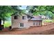 View of the house backyard, bordered by a wooded area and neighboring houses at 849 Cadet Nw Ct, Lilburn, GA 30047