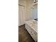 Bathroom with white vanity, laminate flooring, and mirror showing bedroom area at 849 Cadet Nw Ct, Lilburn, GA 30047