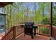 View of the deck featuring a gas grill and railing overlooking a wooded area at 1890 Spalding Dr, Atlanta, GA 30350