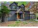 Charming exterior featuring a covered porch with stone accents and a natural wood door at 1890 Spalding Dr, Atlanta, GA 30350