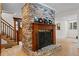 Living room fireplace with brick surround, wooden mantel, and adjacent staircase at 1890 Spalding Dr, Atlanta, GA 30350