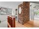 Hallway featuring exposed brick accent wall with hardwood floors and natural light from nearby windows at 1890 Spalding Dr, Atlanta, GA 30350