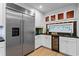 Kitchen wet bar with stainless steel refrigerator, beverage cooler, dark countertops, and custom stain-glass window at 1890 Spalding Dr, Atlanta, GA 30350