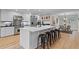 Bright kitchen features white cabinets, stainless steel appliances, and a large island with seating at 1890 Spalding Dr, Atlanta, GA 30350